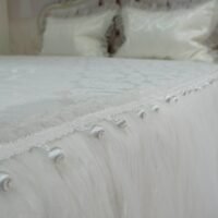 Pagal individualų užsakymą. Prabangi lovatiesė Emilija kreminės spalvos dekoruota tiulio smulkiomis klostėmis ir prabangiu baltu kutu 260×260