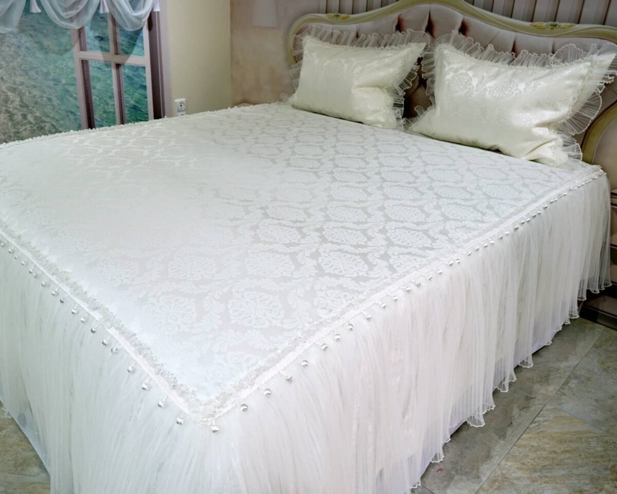 Pagal individualų užsakymą. Prabangi lovatiesė Emilija kreminės spalvos dekoruota tiulio smulkiomis klostėmis ir prabangiu baltu kutu 260×260